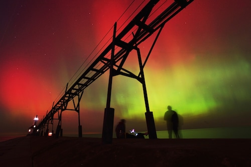 ]An aurora borealis, also known as the northern lights, lights up the night sky off Lake Michigan and the St. Joseph Lighthouse, Oct. 10, 2024, in St. Joseph, Mich. (Don Campbell/The Herald-Palladium via AP, File)