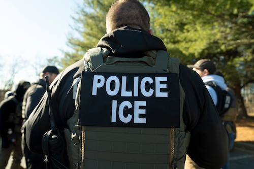 A U.S. Immigration and Customs Enforcement officer listens during a briefing