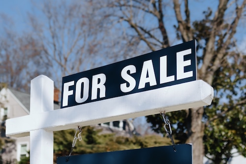 A for sale sign is posted outside a house