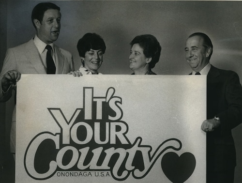 "It's Your County - Onondaga, U.S.A." was the slogan used by the local Democratic Party for races in 1979. The party looked to continue its control of the County Legislature. This was before a clambake at the Jamesville home of Mr. And Mrs. Frank Bean. Holding a poster are, from left, County Legislature Chairman Michael Bragman. Phyllis Battaglia, committee co-chairman; and Betty and Frank Bean, hosts for the clambake.