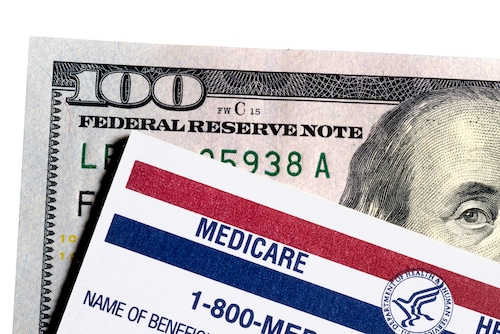 A Medicare card sits on top of U.S. paper currency