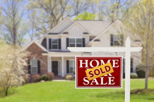 Sold home for sale real estate sign in front of a house