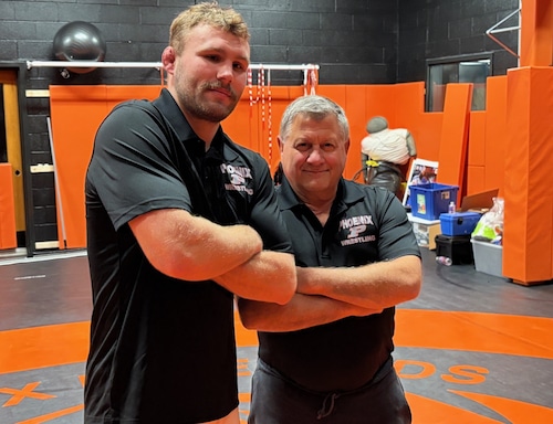 Ross McFarland, left, has taken over as head coach of Phoenix wrestling, replacing his mentor, Gene Mills.