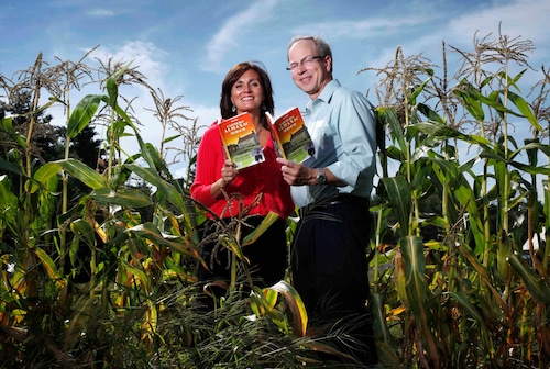 FILE - Farmers' Almanac editor Sondra Duncan and publisher Peter Geiger pose in a corn field with the 2012 edition of the almanac, Aug. 24, 2011, in Auburn, Maine. (AP Photo/Robert F. Bukaty, File)